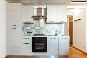 a kitchen with white cabinets and a stove top oven at Casa Vacanza Madonnella 10 in Sperlonga