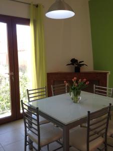 una mesa de comedor con un jarrón de flores. en Ampio appartamento Sulcis Iglesiente Sardegna, en Gonnesa