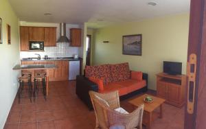 a living room with a couch and a kitchen at APARTAMENTOS RURALES AZABACHE in Villaviciosa