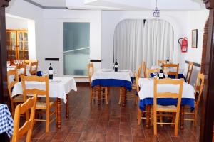 a restaurant with two tables with blue and white tablecloths at Hospedería Ancladero in Mojácar