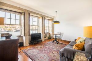 ein Wohnzimmer mit einem Sofa und einem TV in der Unterkunft Porto Premium River View I in Porto