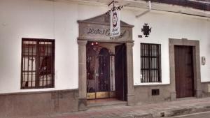 une porte menant à un bâtiment avec des portes en fer forgé dans l'établissement Hotel y Restaurante Colonial Popayan, à Popayan