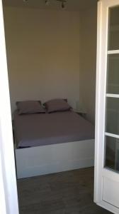 um quarto com uma cama com lençóis e almofadas roxos em Le Laodis em La Ciotat