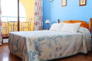 a bedroom with a bed with a blue wall at Hospedería Ancladero in Mojácar