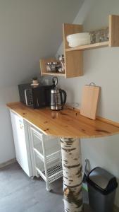 a kitchen with a wooden counter with a table and a tree gmaxwell gmaxwell gmaxwell gmaxwell at Pokoje Gościnne Nad Złotym Potokiem in Jarnołtówek