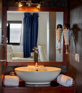 a bathroom with a sink and a mirror at Hotel LIVVO Budha Beach in Santa Maria
