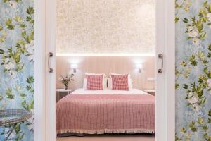 a bedroom with a bed with pink sheets and a window at Feelathome San Marcos Apartments in Madrid