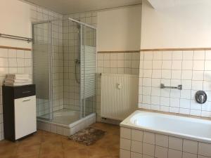 ein Badezimmer mit Badewanne und Glasdusche in der Unterkunft SAD100 - Gemütliche Monteurwohnungen in Schwandorf in Schwandorf in Bayern
