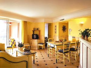 a kitchen with yellow walls and a table and chairs at Lagrange Vacances Port-Marine in Sainte-Maxime