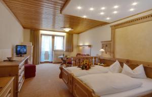 ein Hotelzimmer mit 2 Betten und einem TV in der Unterkunft Hotel Bergheimat in Schönau am Königssee