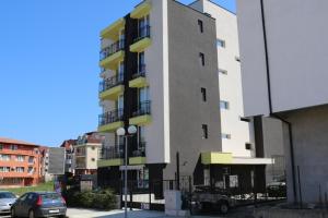 a tall building with cars parked in front of it at сем. Павлови in Obzor