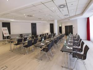 a large room with tables and chairs in it at DORMERO Hotel Dessau-Roßlau in Dessau