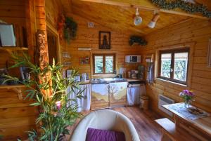 una cocina en una cabaña de madera con bañera en Chalet à fleur de rêve en Maroilles