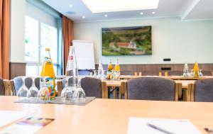 una sala conferenze con tavoli e sedie con bottiglie sopra di Hotel Waldmühle a Zella-Mehlis