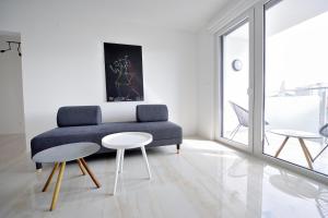 sala de estar con sofá azul y 2 mesas en Center Aupark Apartment en Piešťany