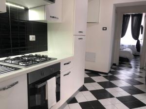 a kitchen with a white stove top oven and white cabinets at Camaldoli House in Milan