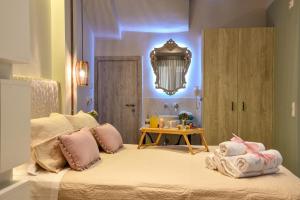 Un dormitorio con una cama con almohadas rosas y una mesa. en Suite 16 en Corfú