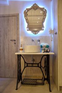 baño con lavabo y espejo en la pared en Suite 16 en Corfú