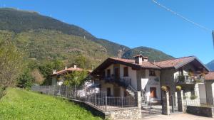 una casa en una colina con montañas en el fondo en Casa Vacanza Dal Contadino CIR O17063, en Alpe Strencia