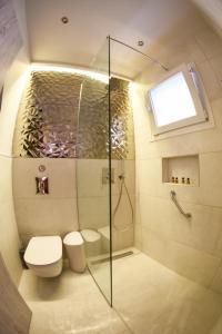 a bathroom with a shower and a toilet and a window at Suite 16 in Corfu Town