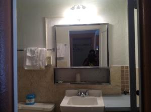 a bathroom with a sink and a mirror at Budget Inn Motel Chemult in Chemult +29 photos