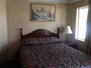 1 dormitorio con 1 cama y una foto en la pared en Budget Inn Motel Chemult en Chemult