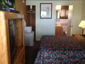 a hotel room with a bed and a television at Budget Inn Motel Chemult in Chemult
