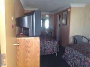 
a hotel room with a bed and a television at Budget Inn Motel Chemult in Chemult
