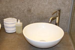 a white sink with a faucet and a bottle of soap at Residentie TYL - Leopoldlaan 122 in Knokke-Heist +8 photos