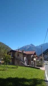 a house on the side of a road with mountains in the background at Casa Vacanza Dal Contadino CIR O17063 in Alpe Strencia