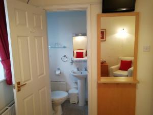 a small bathroom with a toilet and a sink at Green Haven Guest House in Stratford-upon-Avon