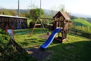 a playground with two swings and a slide at Agriturismo Stazione di Monta in Vicchio