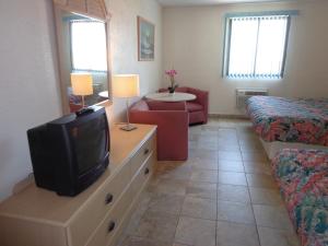 Habitación con TV, cama y sofá. en Isle of Palms Motel, en Wildwood