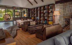 sala de estar con muebles de cuero y pared de piedra. en Hotel Boutique Casadoca, en Concón