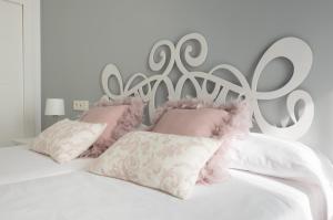 マラガにあるSeafront La Malagueta Iの白いベッド(ピンクの枕、金属製のヘッドボード付)