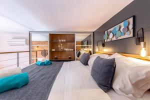 - une chambre avec un grand lit blanc et des oreillers bleus dans l'établissement Studio apartments Atelier, à Rijeka