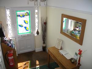 a living room with a tv and a desk at Green Haven Guest House in Stratford-upon-Avon