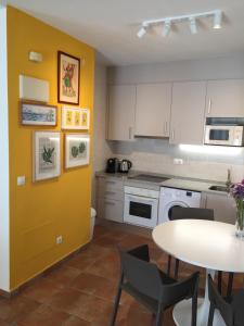 een keuken met een tafel en een gele muur bij CENTRICO APARTAMENTO 2A in Alicante