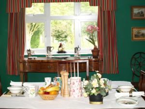 a table with a window and a table with fruit at The Newnham White House in Baldock