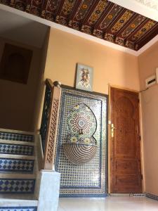 Cette chambre est dotée d'un escalier et d'une porte avec un mur en mosaïque. dans l'établissement Flashback House, à Marrakech