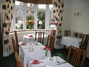 亞芬河畔史特拉福的住宿－Green Haven Guest House，一间用餐室,配有2张带白色桌布的桌子
