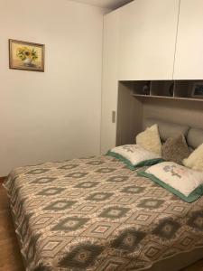 1 dormitorio con 1 cama con 2 almohadas en Apartment with garden and terrace beautiful lake view en Bellano