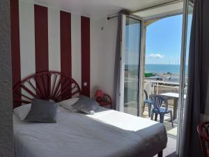 een slaapkamer met een bed en een balkon met uitzicht op de oceaan bij Les Rochers in Carnac
