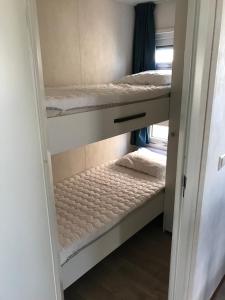 kilka łóżek piętrowych w pokoju w obiekcie Blauwe Zeedistel w mieście IJmuiden
