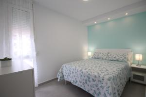 a white bedroom with a bed and a window at Apartment with terrace in Playa de Las Americas in Playa de las Americas