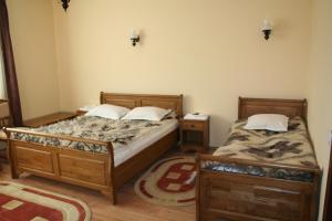 two twin beds in a room with two tables at Cabana Iza in Bîrsana +19 photos
