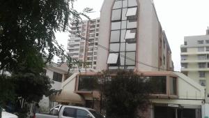 a building with a car parked in front of it at Hotel Cantamar in Viña del Mar