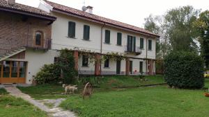 dom z psem stojącym przed nim w obiekcie Agriturismo Cascina Poscallone w mieście Abbiategrasso