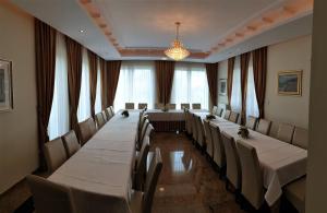a conference room with long tables and chairs and a chandelier at Villa Mechelinka in Mechelinki