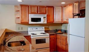 a kitchen with wooden cabinets and a white refrigerator at The Pointe at Castle Hill Resort & Spa in Ludlow